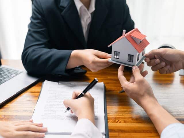Couple receiving house keys from a real estate lawyer at closing
